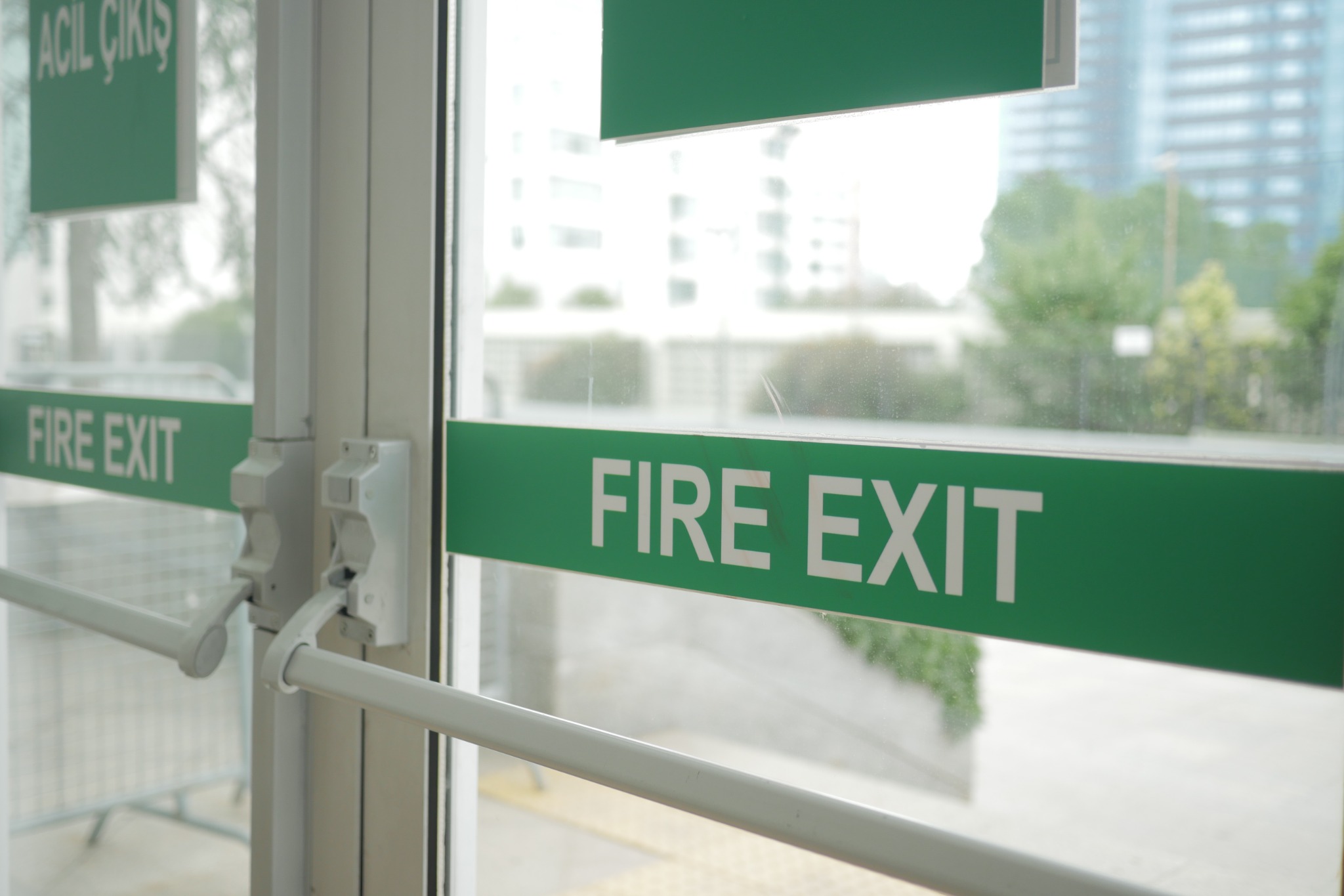 Fire exit doors with push bars and green fire exit signage